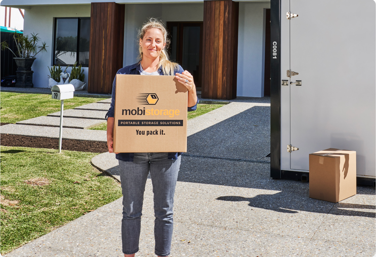 A woman carrying a mobistorage brown box