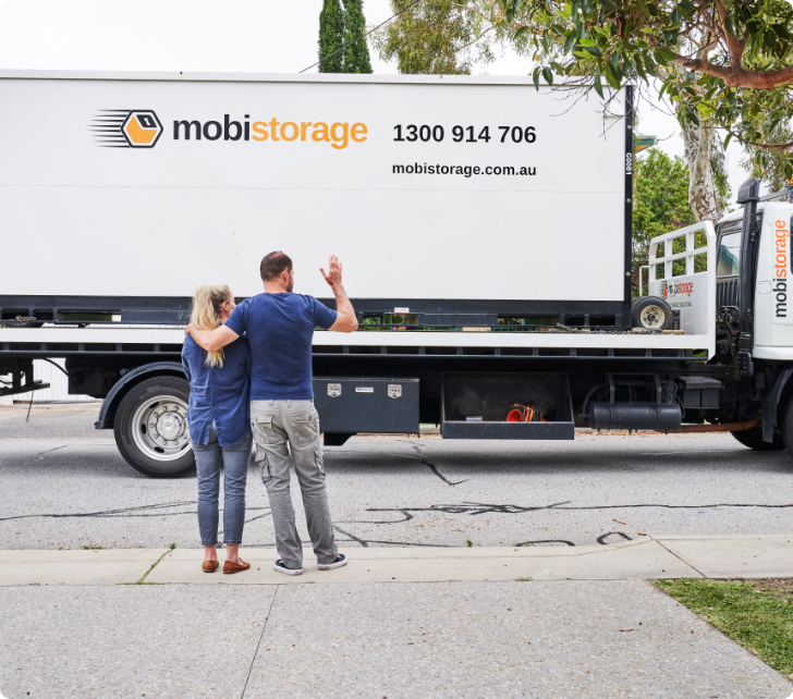 women and man waving to mobistorage truck driver
