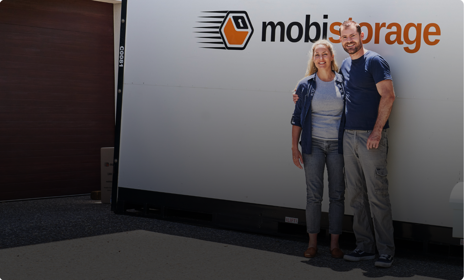 man and women standing outside of mobistorage container