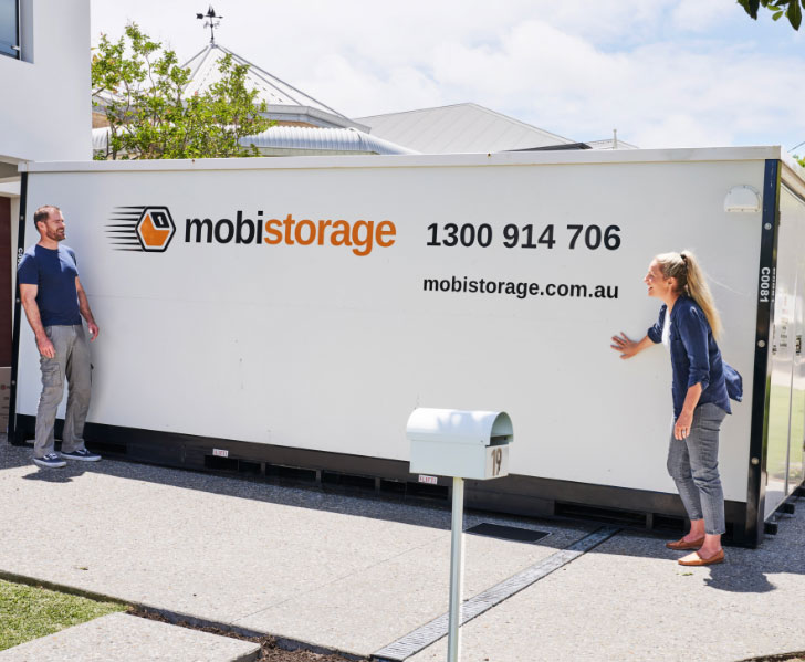 A couple standing outside a mobistorage container